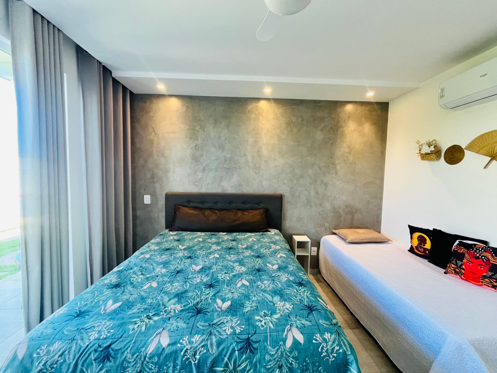 Quarto com cama de casal, cama auxiliar, ar-condicionado e cortinas